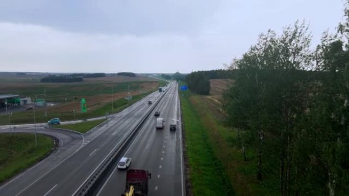 道路和运输的鸟瞰图。人们在高速公路上开车旅行。背景上的白俄罗斯荣耀纪念碑。戏剧性的天空。物流和旅行概