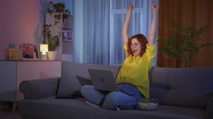 激动的情绪激动的年轻女子看着笔记本电脑感到中奖者对彩票投注中标的感到惊讶，庆祝互联网好消息拥抱胜利成