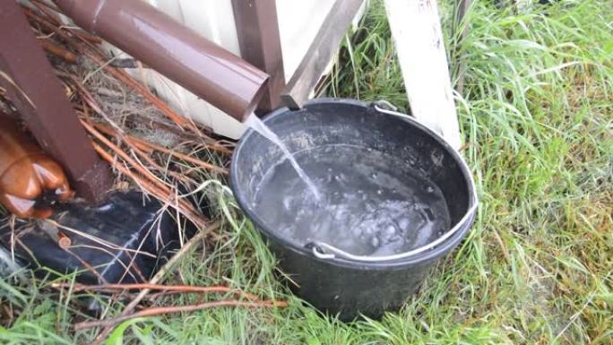 水从房子里倾泻到水桶里
