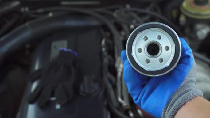 机油滤清器更换汽车发动机维修机械师手握手套特写
