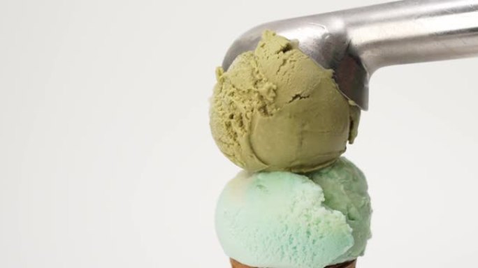 手勺冰淇淋绿茶顶部彩虹彩色风味冰淇淋蛋卷白色背景。