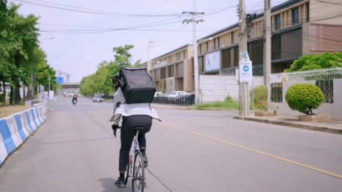 亚洲人在城市里骑自行车运送食物。