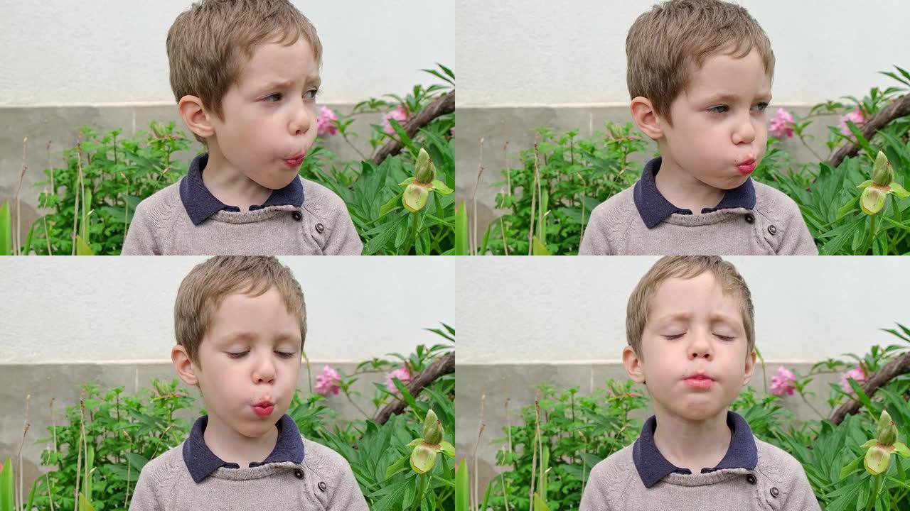 吃甜草莓的漂亮男孩。小孩子在吃红莓