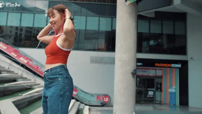 亚洲潮女在城市听音乐时跳舞