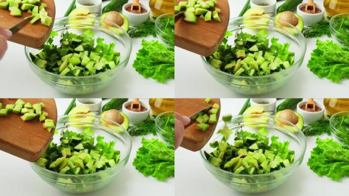 女人烹饪新鲜绿色蔬菜和香草沙拉。生食概念。素食菜单。烹饪健康饮食或素食。女性的手将鳄梨切成绿色蔬菜包