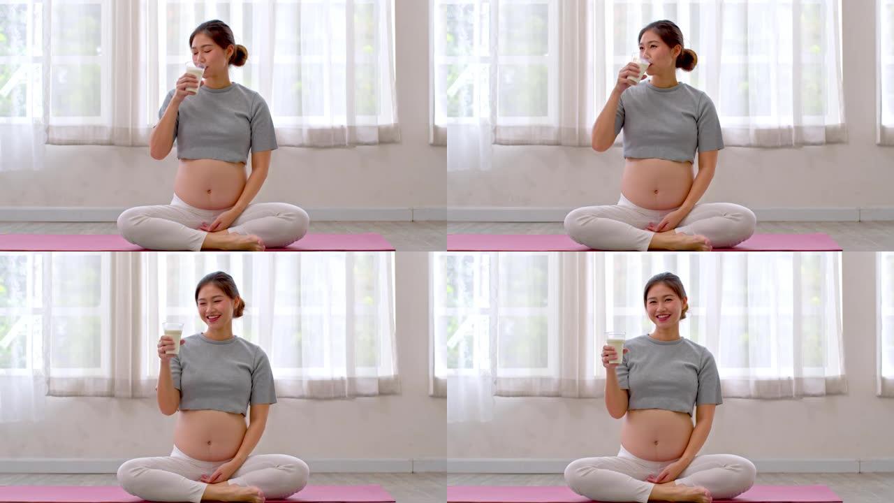 孕妇亚洲妇女喝新鲜牛奶为婴儿提供良好的钙和蛋白质来源，健康孕妇享受豆浆帮助成长中的婴儿建立强壮的骨骼