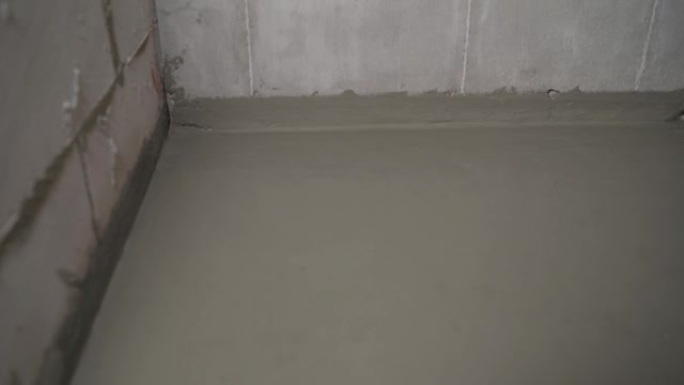 用刷子和砂浆给地板防水。地板防水。主人用刷子处理地板