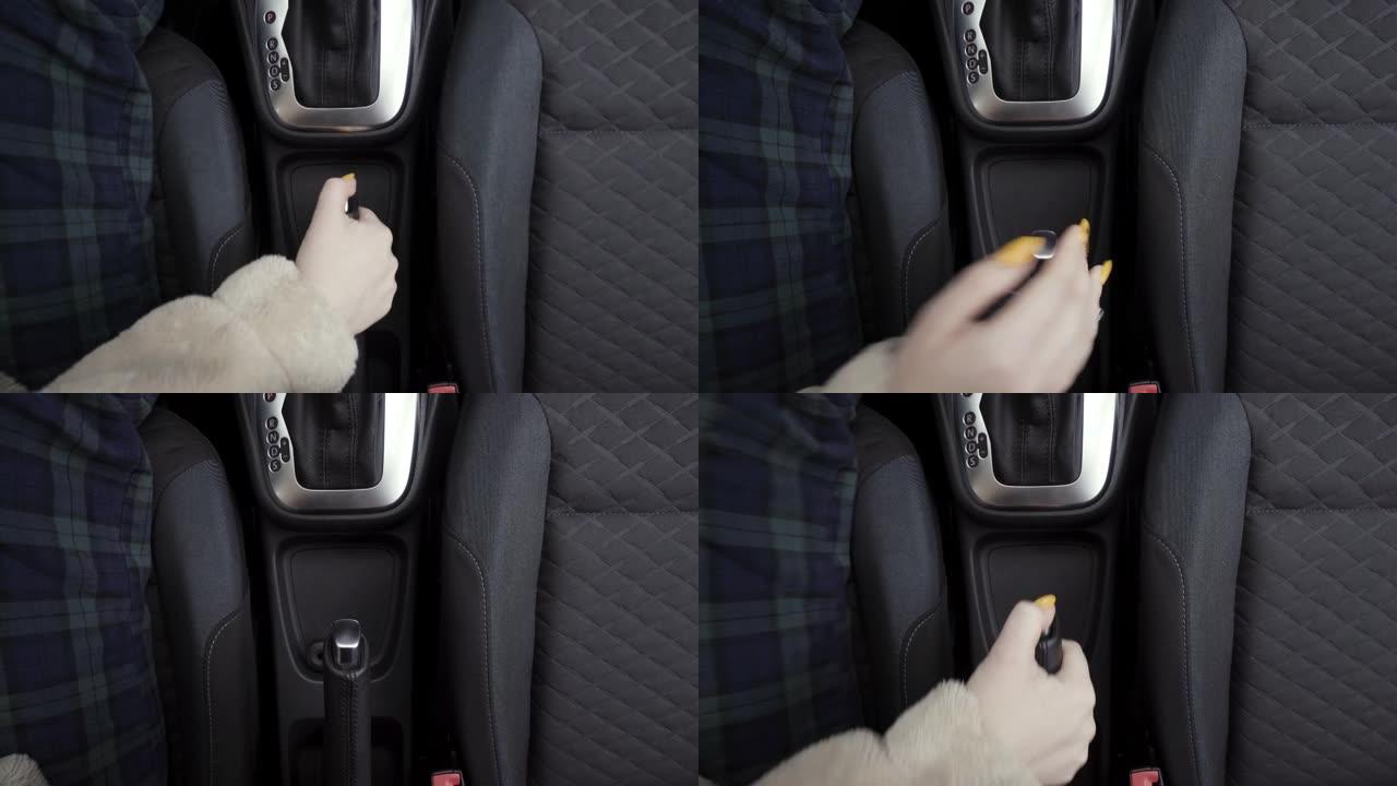 司机女人控制汽车，拉手刹。行动。关闭女性手举起手刹并松开手刹的俯视图。