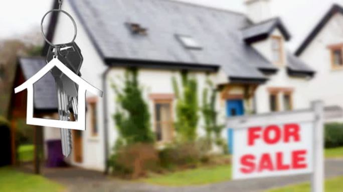 银色房子钥匙扣和钥匙的动画，挂在模糊房子前面，有待售标志