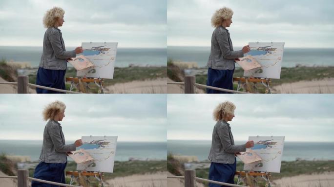 中年欧洲妇女，艺术家，用原始的海景描绘海景。慢动作