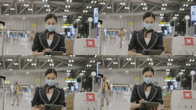 泰国自信的女性主动乘务员，戴着防护口罩，使用平板电脑更新航空业病毒大流行信息-股票视频