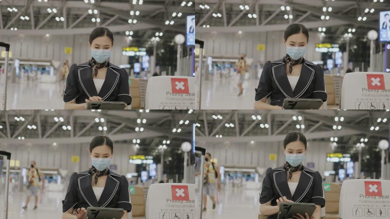 泰国自信的女性主动乘务员，戴着防护口罩，使用平板电脑更新航空业病毒大流行信息-股票视频