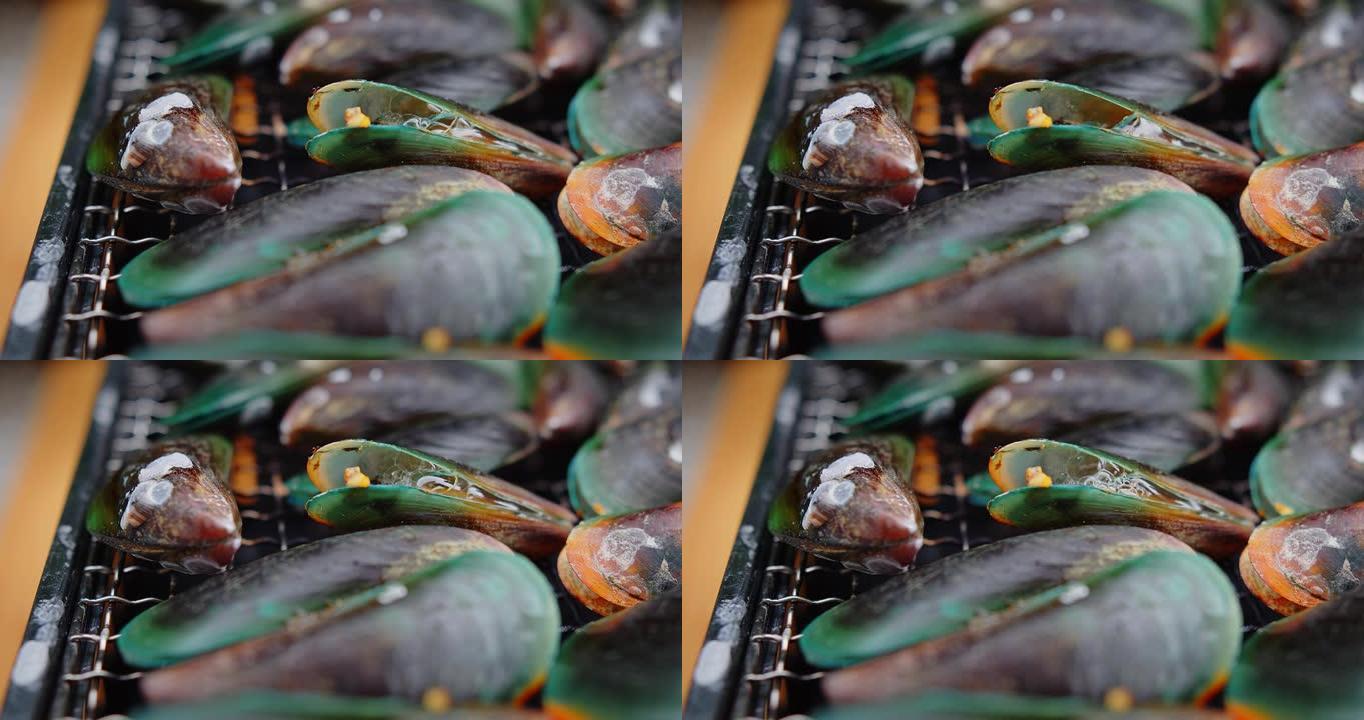 大量新鲜多汁的绿壳贻贝在热炭炉上烤热水气泡，烹饪海鲜派对