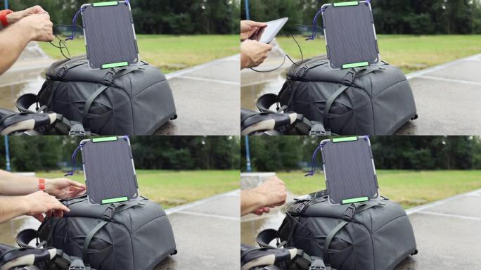 骑自行车的人使用背包上的太阳能电池板为平板电脑充电。