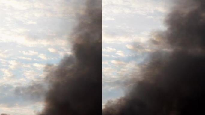 天空中的黑烟。着火、燃烧农业垃圾、工厂管道或爆炸。烟雾旋转并被风带走。