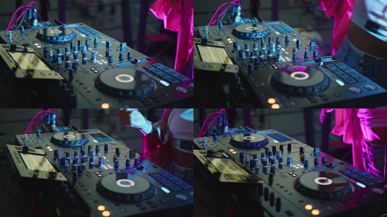 特写。DJ音响控制台，用于在迪斯科俱乐部混合舞蹈音乐。双手触摸按钮滑块，在混音台上播放电子音乐，在夜