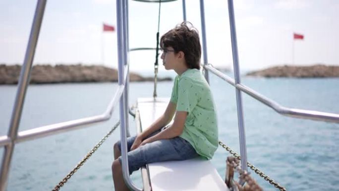 在夏季航行中航行游艇上的小男孩