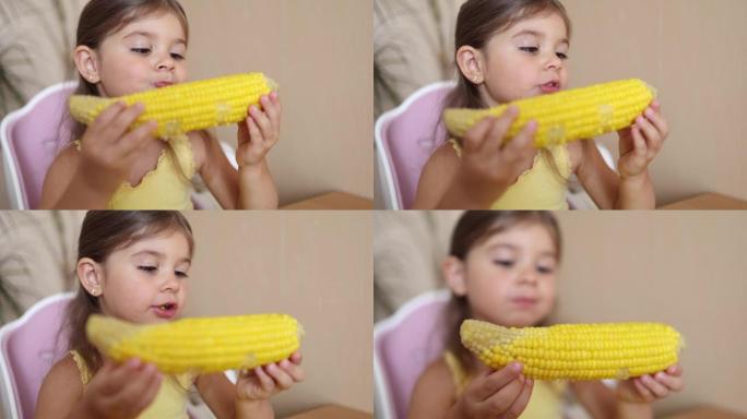 可爱的小女孩在家吃玉米。可爱的孩子树岁吃沸腾的玉米