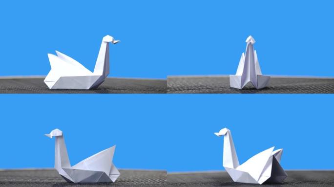 蓝色背景上的白色折纸天鹅。