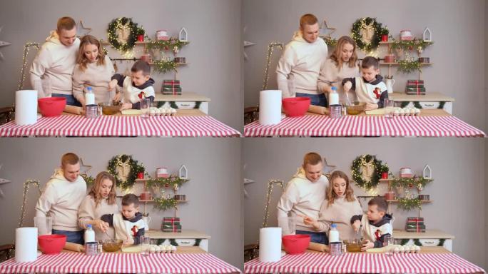 一个小男孩用打蛋器打面团。一家人一起为新年做准备