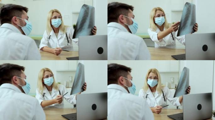 医生医生在医用口罩专家显示肺部的x射线图像，以患者解释在现代私立医院工作的症状。