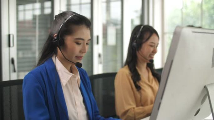 年轻的女性呼叫中心代理在其工作站上与客户交谈