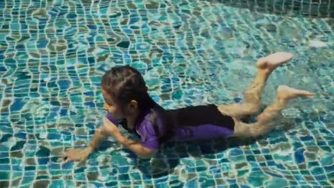 穿着泳衣的亚洲女孩在户外游泳池玩耍或游泳
