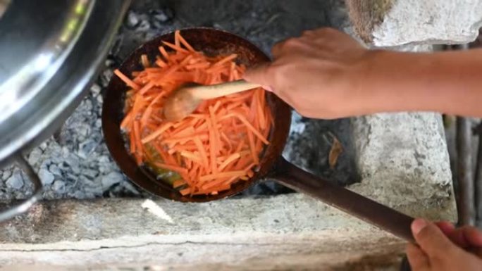用胡萝卜在明火在农村厨房中制作食物的传统方法