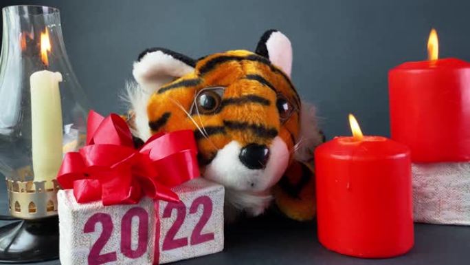 老虎符号2022年年，燃烧蜡烛和礼品盒与文字2022