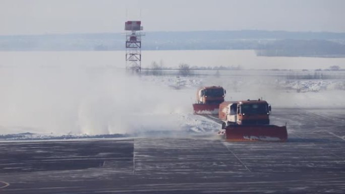 在冬季机场发生暴风雨暴风雪后，扫雪车清除了雪堆。天气条件变化和航班延误的概念