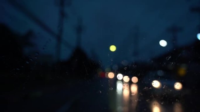 汽车后视镜上的雨滴。汽车前挡风玻璃上的雨水和雨刷。视频慢动作。