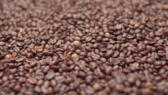 大量咖啡豆落在填充背景的大量咖啡豆上。概念语气和活力