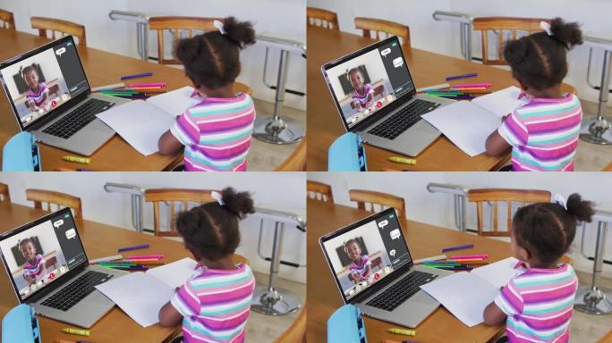 非裔美国女孩在家里做作业并与笔记本电脑上的同学进行视频通话