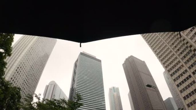 雨天透过雨伞仰望摩天大楼