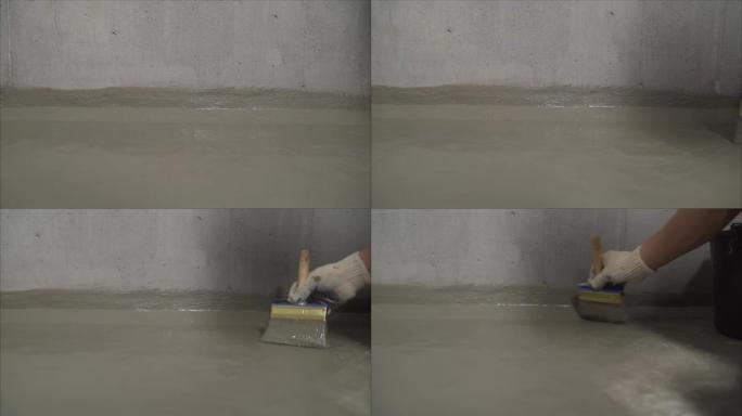 一名工人正在为混凝土地板防水。建筑组合防水。混凝土地板与新鲜建筑防水