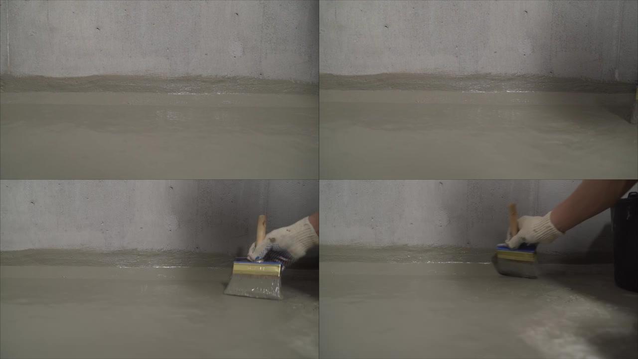 一名工人正在为混凝土地板防水。建筑组合防水。混凝土地板与新鲜建筑防水