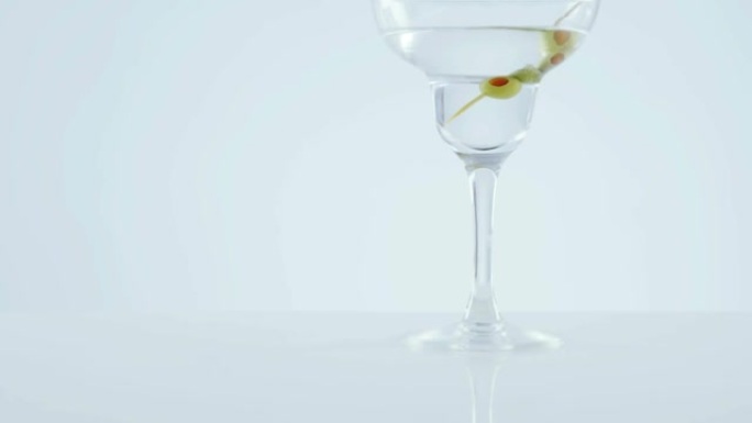 灰色背景下的鸡尾酒玻璃橄榄上的雪佛龙图案设计