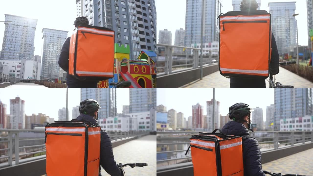 带保暖袋的蒙面送货员携带自行车