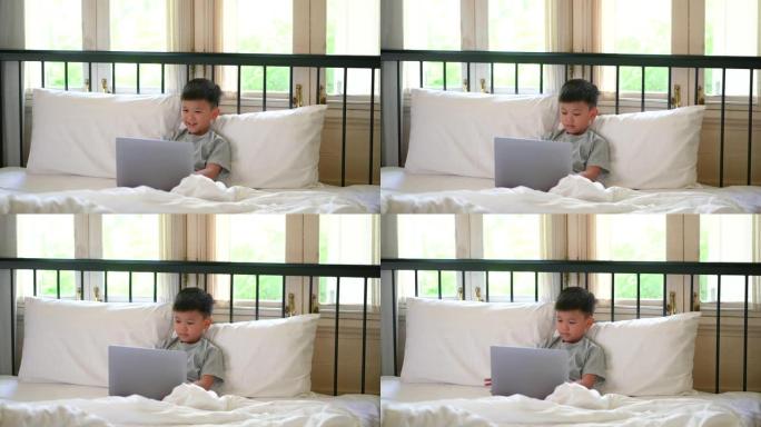 亚洲孩子在床上和沙发上与狗一起学习在线学习。新常态的概念研究与检疫