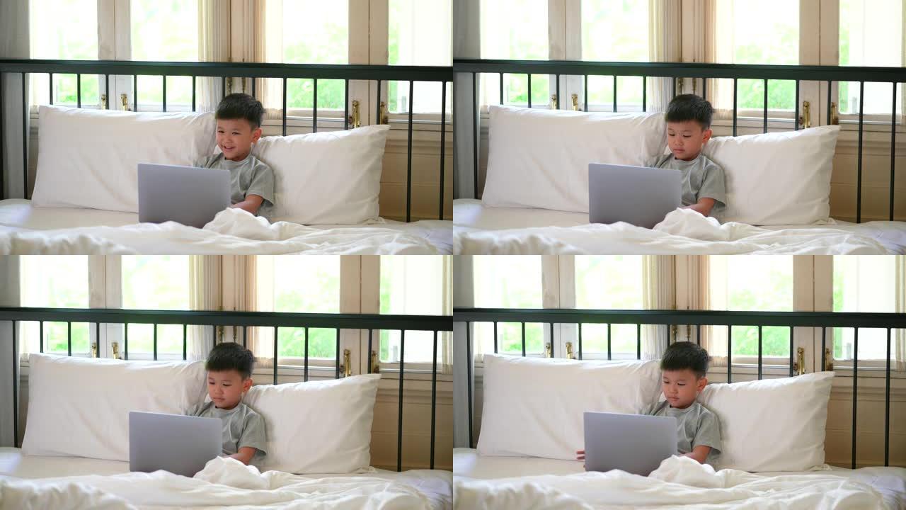亚洲孩子在床上和沙发上与狗一起学习在线学习。新常态的概念研究与检疫