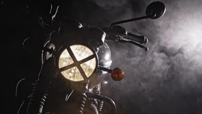 黑色复古风格的摩托车扰频器在雾中夜晚的轮廓。冒险，机动车辆，定制摩托车概念。阴霾背景的黑夜。