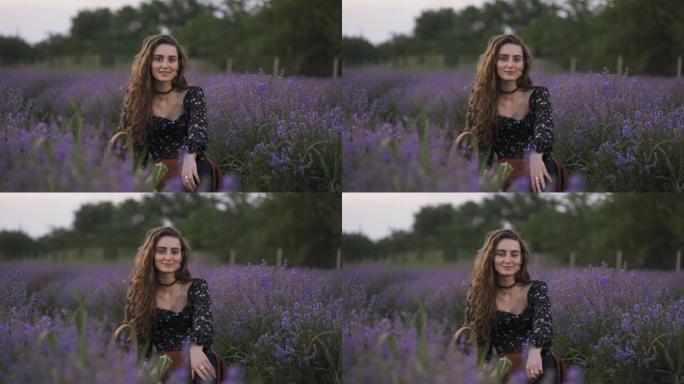 可爱的年轻女子穿着时尚的连衣裙，坐在紫色薰衣草田里