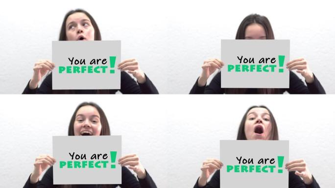 画布框架标签上的概念信息 “你是完美的”，由美丽的女孩微笑着对着镜头