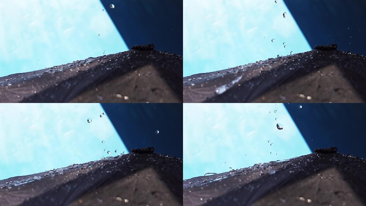水滴落在黑色雨伞上的慢动作视频。