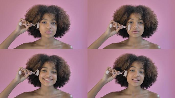 非裔美国模特用玉辊按摩脸颊