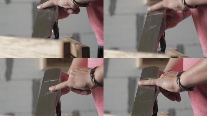 男性工人用油润滑手平面的刀片。木匠用润滑脂润滑飞机。木工艺术。