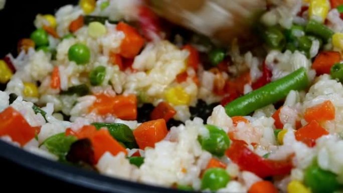 烤墨西哥传统蔬菜在煎锅中混合玉米，红甜椒，青豆，青豌豆，胡萝卜和米饭。