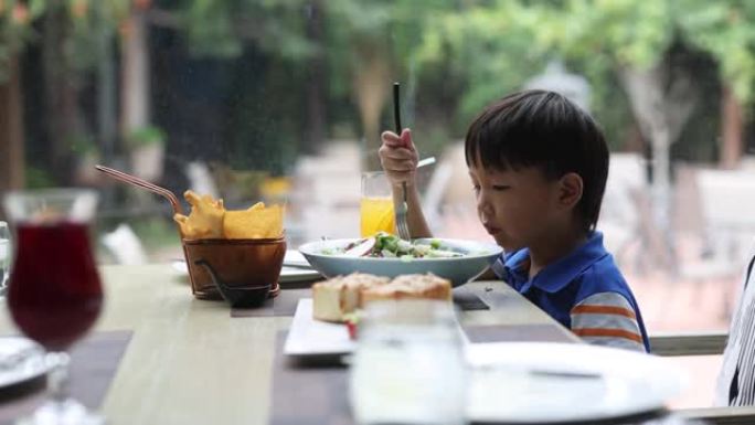 一个在餐馆吃饭的小男孩