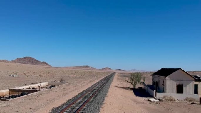 沙漠景观中铁路轨道旁的破旧车站建筑