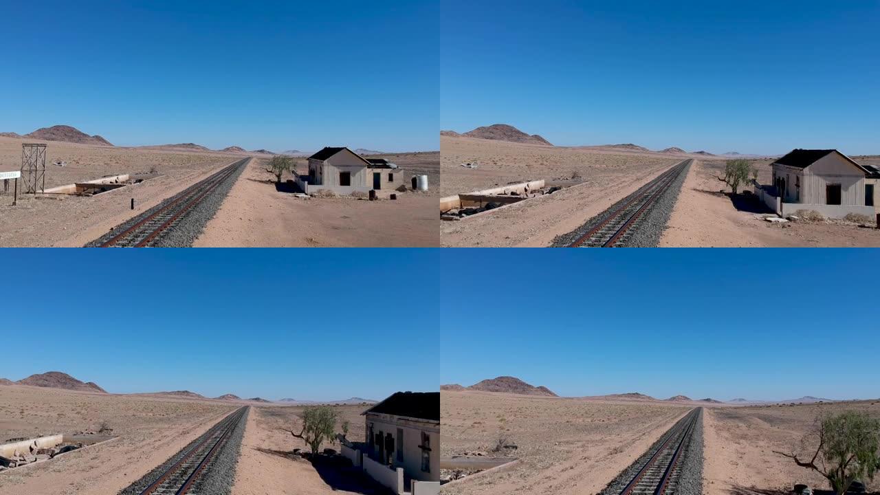 沙漠景观中铁路轨道旁的破旧车站建筑